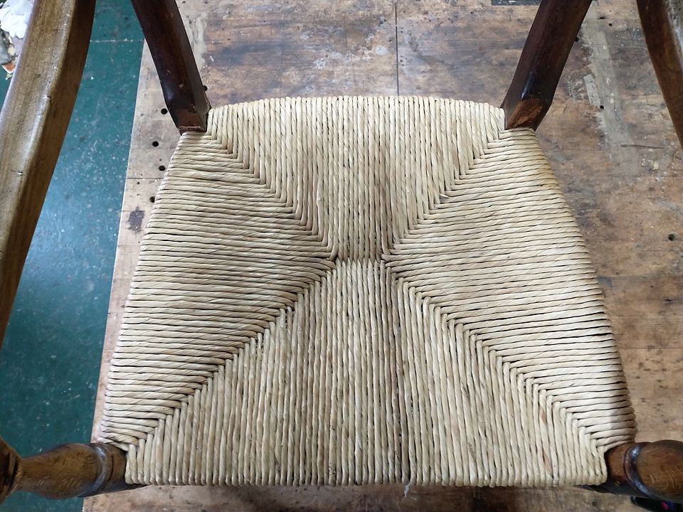 Close-up of a freshly woven rush seat showing the four-way pattern