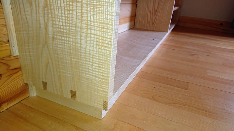 Detail of the fitted shelving: figured end panel with exposed dovetails at the base
